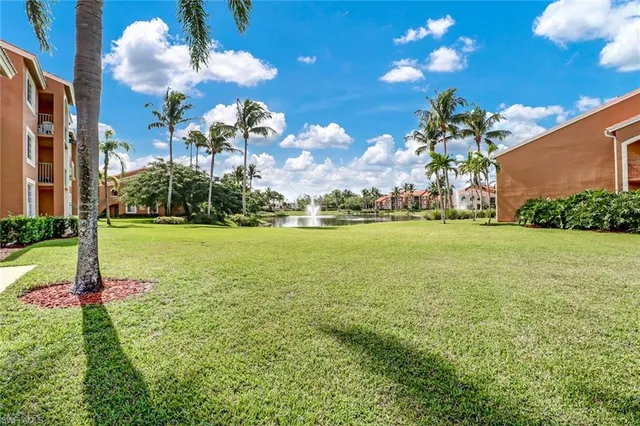 a view of a fountain in front of a house with a big yard