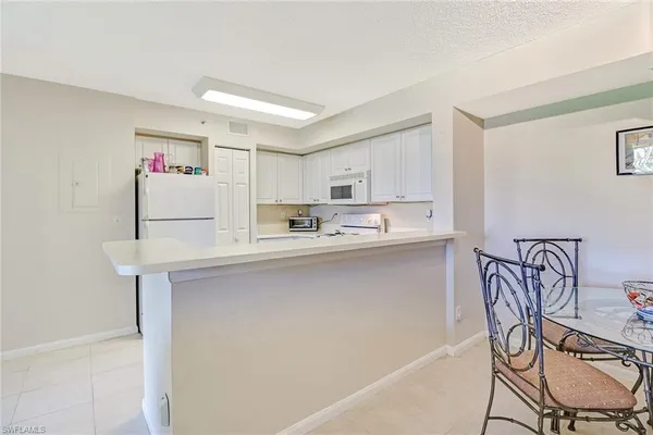 a kitchen with a sink a refrigerator and cabinets