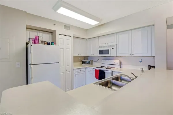 a kitchen with refrigerator a stove a sink and a cabinets