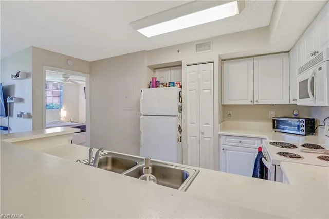 a kitchen with a sink cabinets and appliances