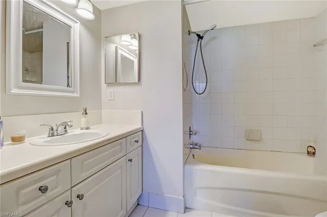 a bathroom with a granite countertop sink a toilet and bathtub