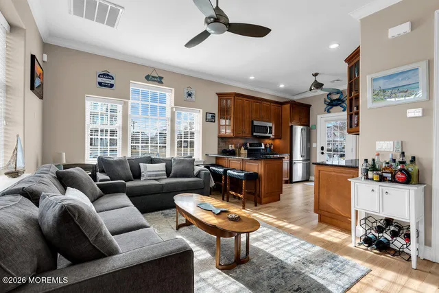 a living room with furniture a rug kitchen view and a window