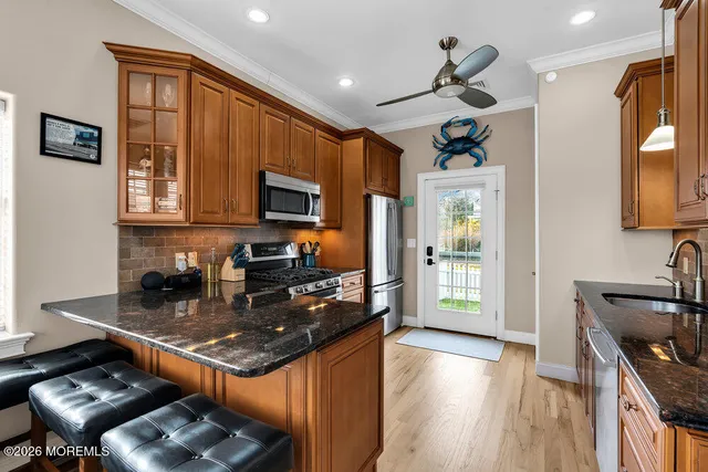 a kitchen with stainless steel appliances granite countertop a stove top oven a sink dishwasher and cabinets with wooden floor
