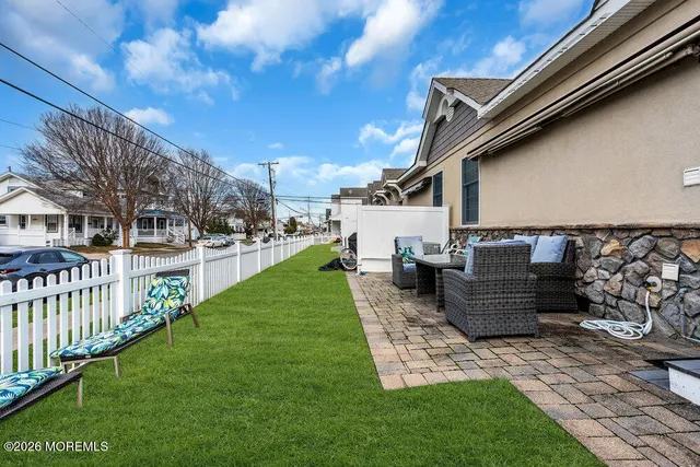 a view of a patio with couches chairs potted plants and a big yard