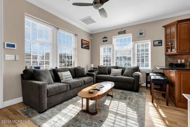 a living room with furniture two windows and a dining table