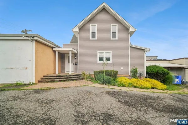 a view of the house with backyard and chairs