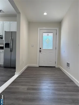 a view of a kitchen with wooden floor a sink and a dishwasher