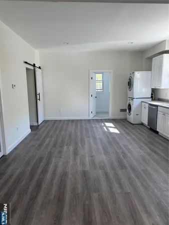 a view of empty room with wooden floor and window