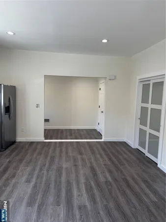a kitchen with a sink wooden floor and stainless steel appliances