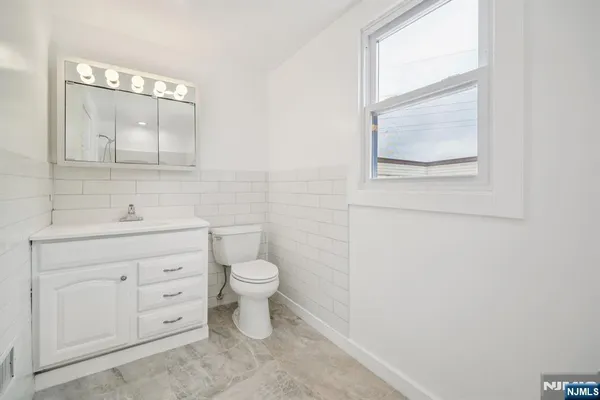 a bathroom with a toilet a sink a vanity and mirror