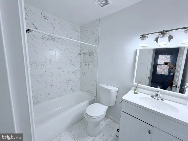 a kitchen with granite countertop a refrigerator and a stove top oven