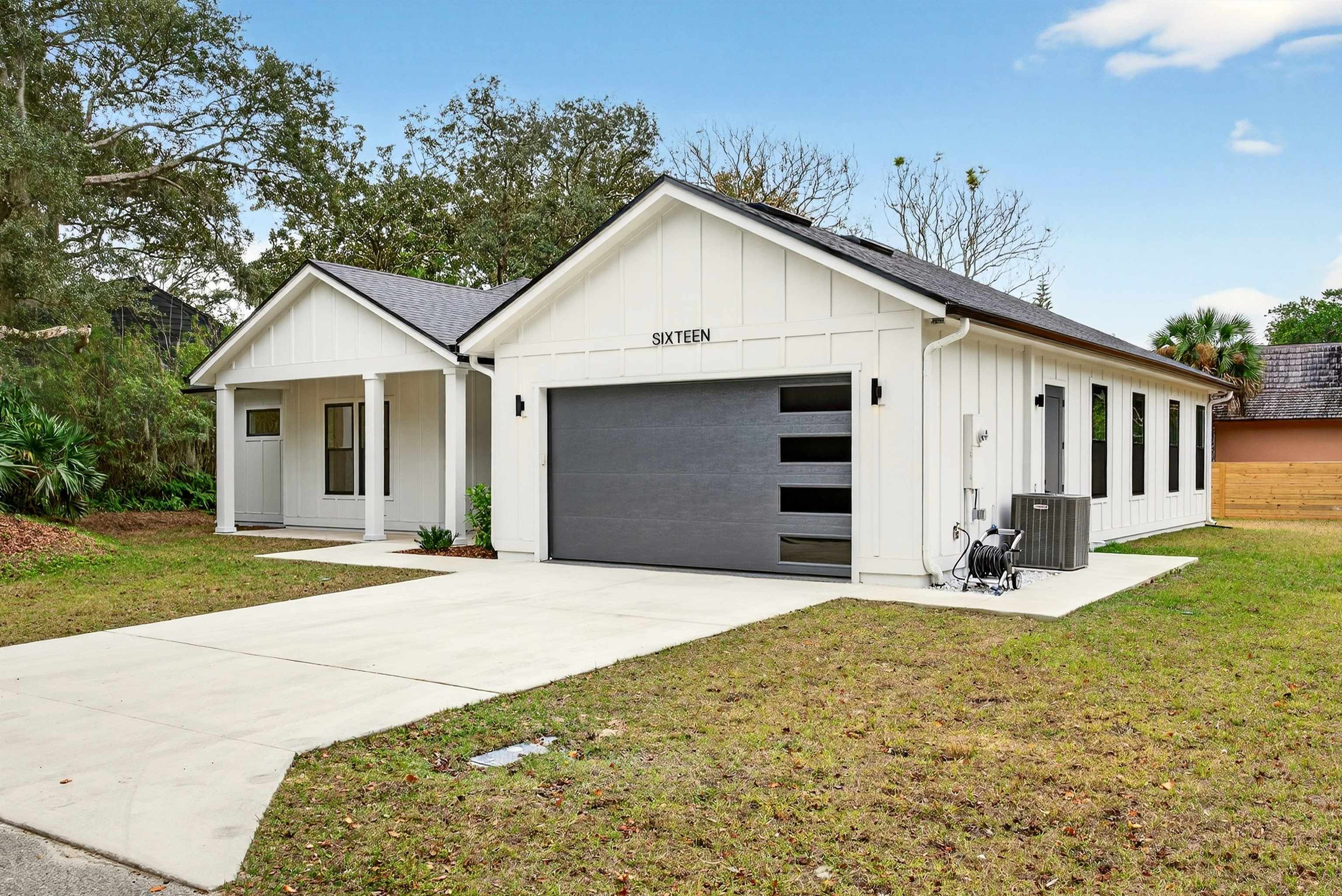 16 Baru Road St. Augustine, FL 32080 - Photo 2 of 73 Modern farmhouse style home featuring board and batten siding, roof with shingles, a front lawn, driveway, and a garage