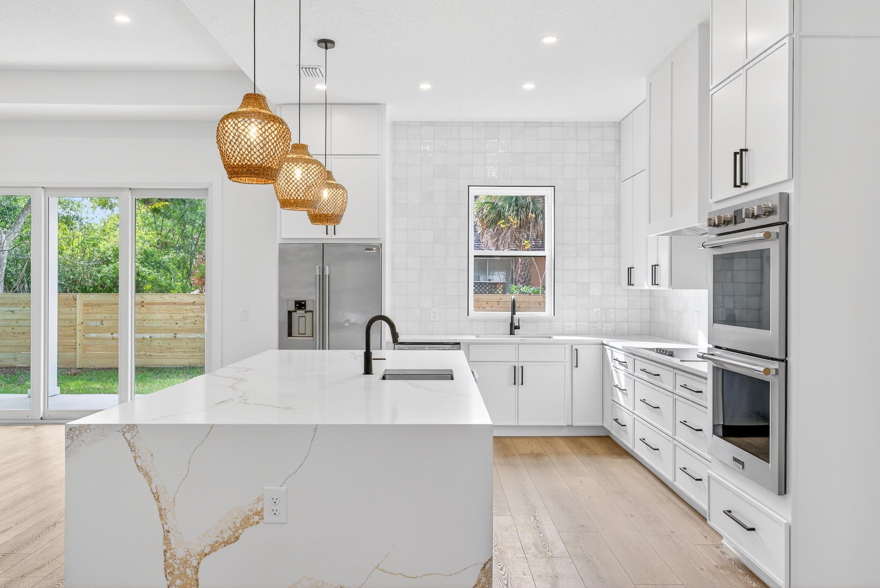 16 Baru Road St. Augustine, FL 32080 - Photo 22 of 73 a large kitchen with white cabinets a sink a stove and a chandelier