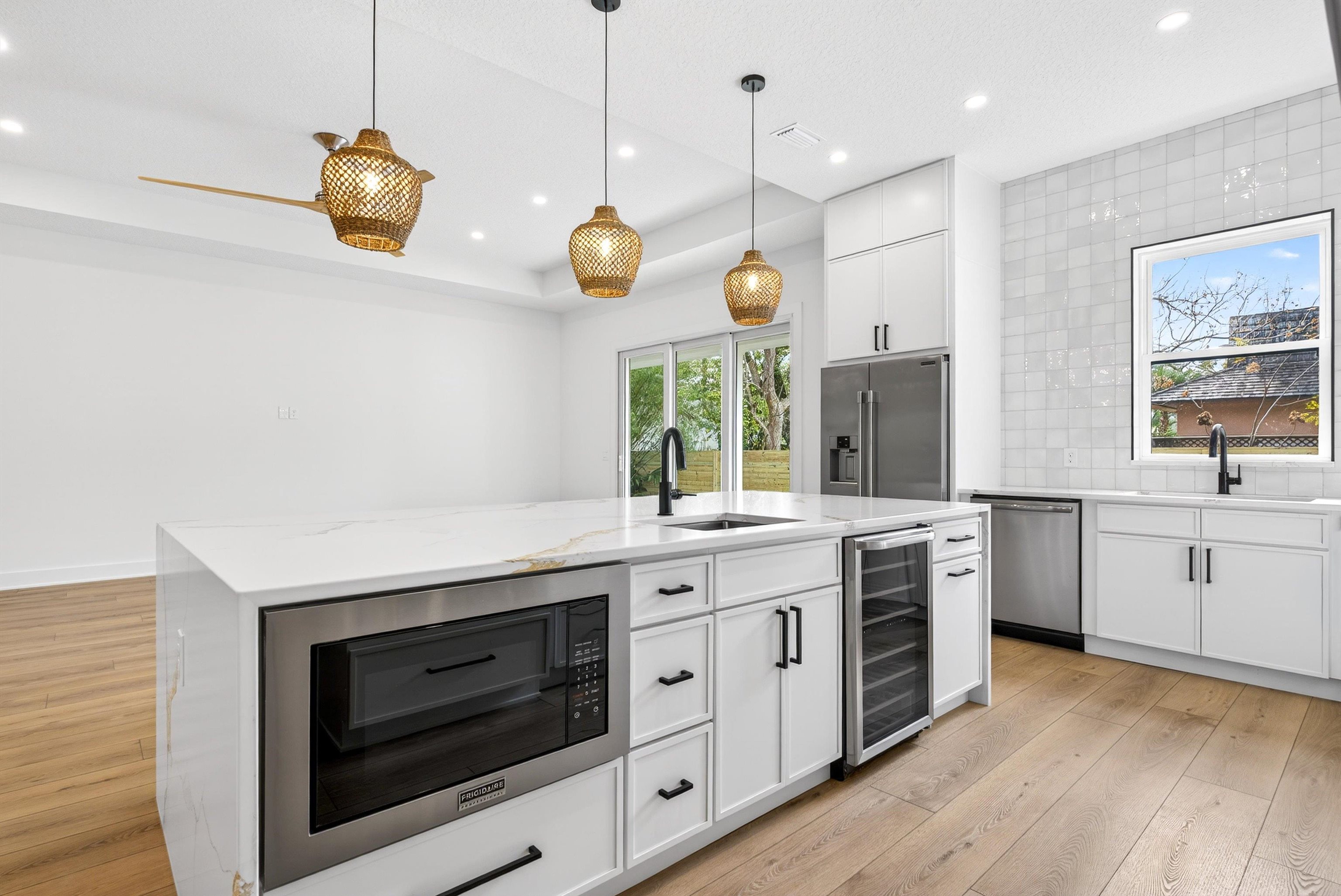 16 Baru Road St. Augustine, FL 32080 - Photo 23 of 73 Kitchen featuring appliances with stainless steel finishes, light wood-style floors, white cabinetry, tasteful backsplash, and recessed lighting