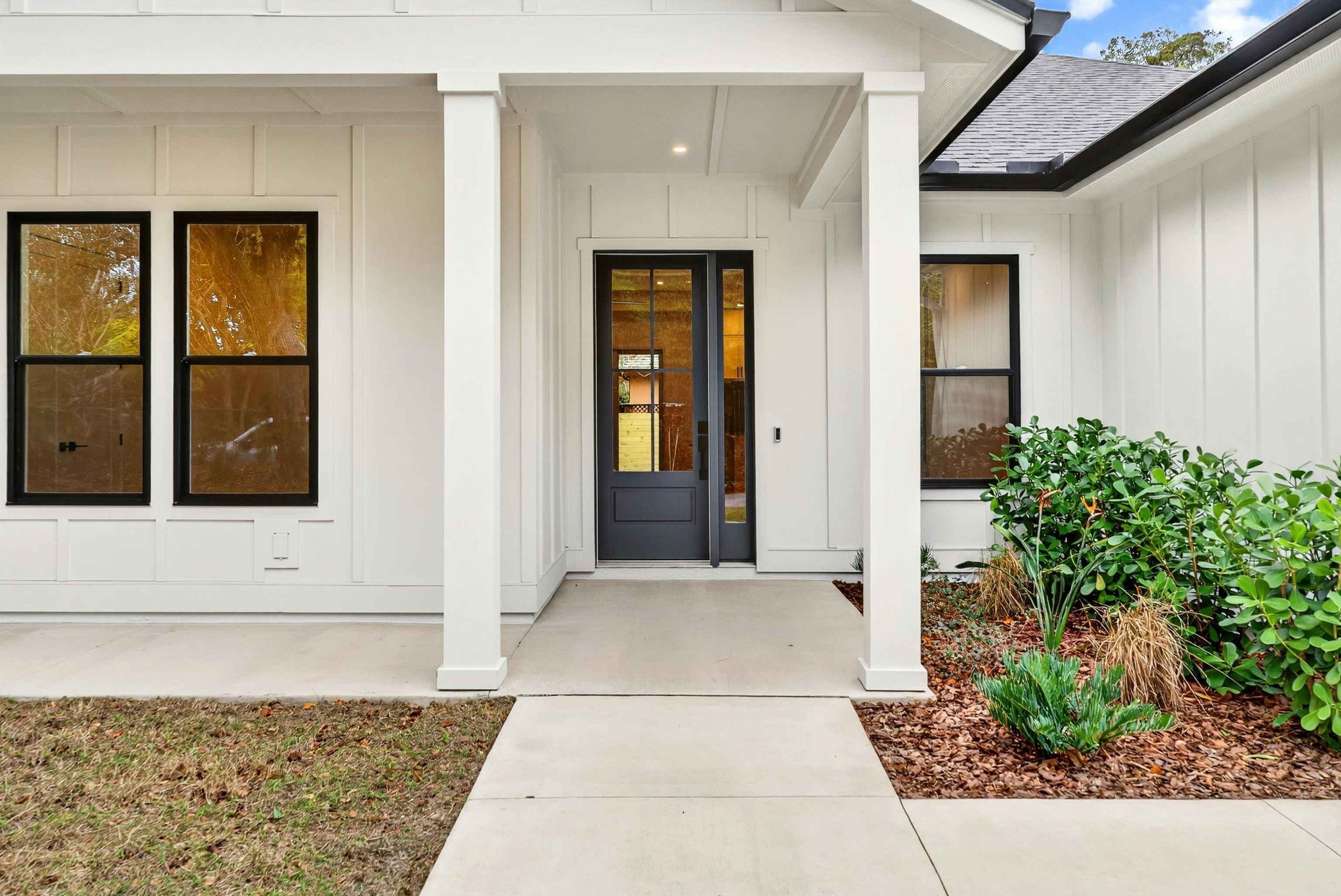 16 Baru Road St. Augustine, FL 32080 - Photo 8 of 73 View of exterior entry featuring board and batten siding, covered porch, and a shingled roof