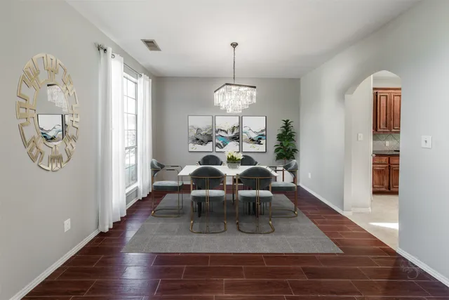 a view of a dining room with furniture a chandelier and wooden floor