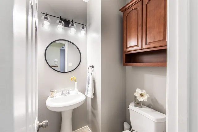 a bathroom with a toilet sink and mirror