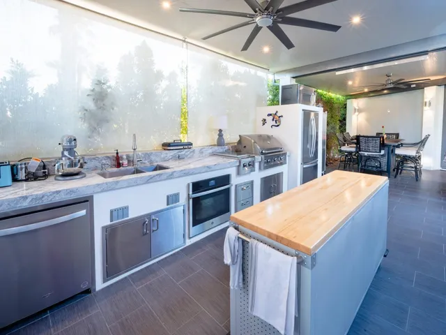 a kitchen with stainless steel appliances granite countertop a sink a stove and a refrigerator