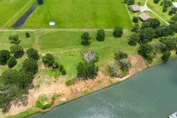 an aerial view of residential houses with outdoor space and trees all around