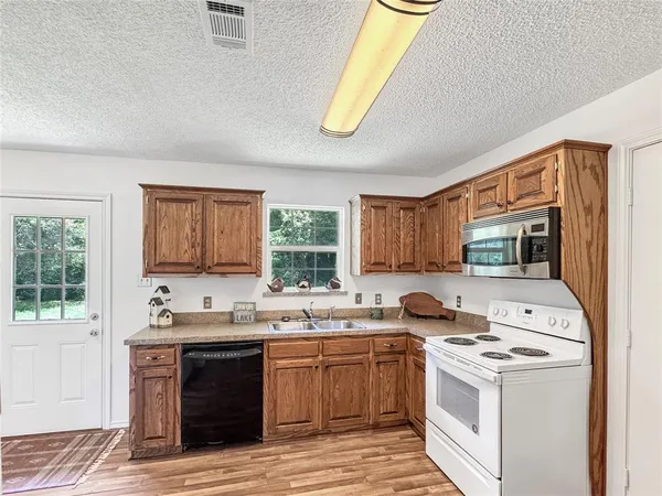 a kitchen with a stove a sink and a window
