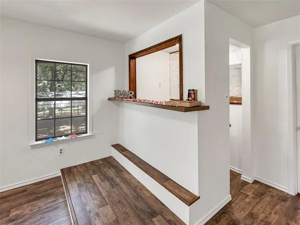 a view of a room with wooden floor and a window