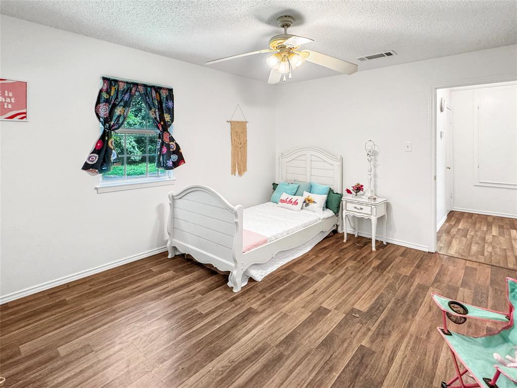 1005 Wood Canyon Road Tool, TX 75143 - Photo 17 of 26 a bedroom with a bed and a chandelier