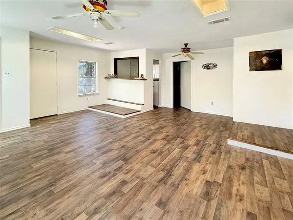 a view of a livingroom with wooden floor and a ceiling fan