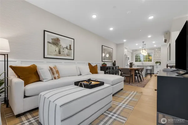 a living room with furniture a flat screen tv and kitchen view