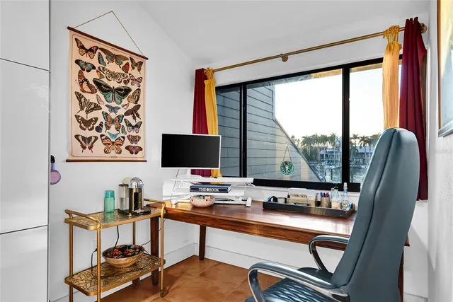 a view of a workspace with furniture and a window