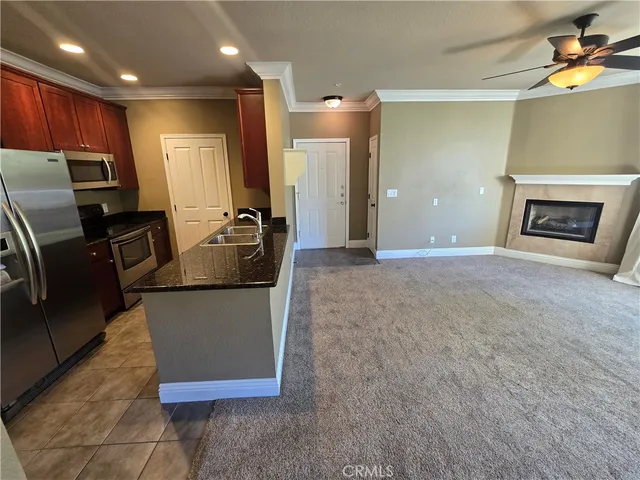 a kitchen with granite countertop a refrigerator and a stove top oven