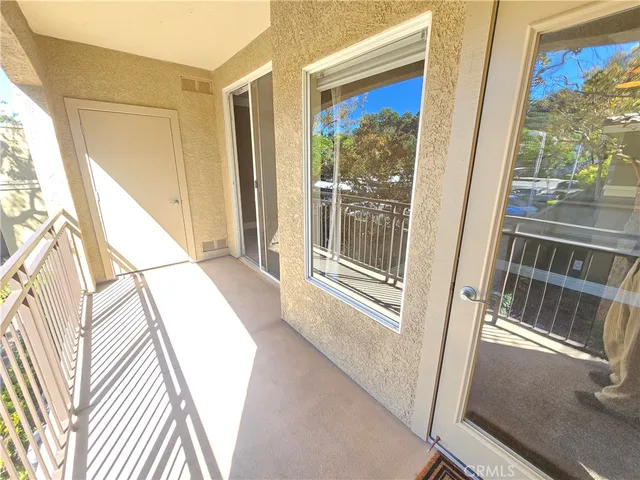 a view of a balcony with wooden floor and door
