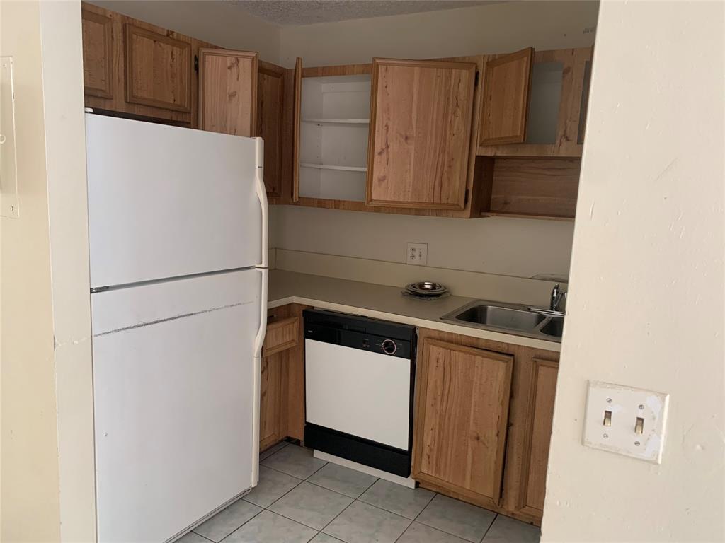 10850 Royal Palm Boulevard, Unit 10850 Coral Springs, FL 33065 - Photo 4 of 8 a white refrigerator freezer and a stove sitting inside of a kitchen