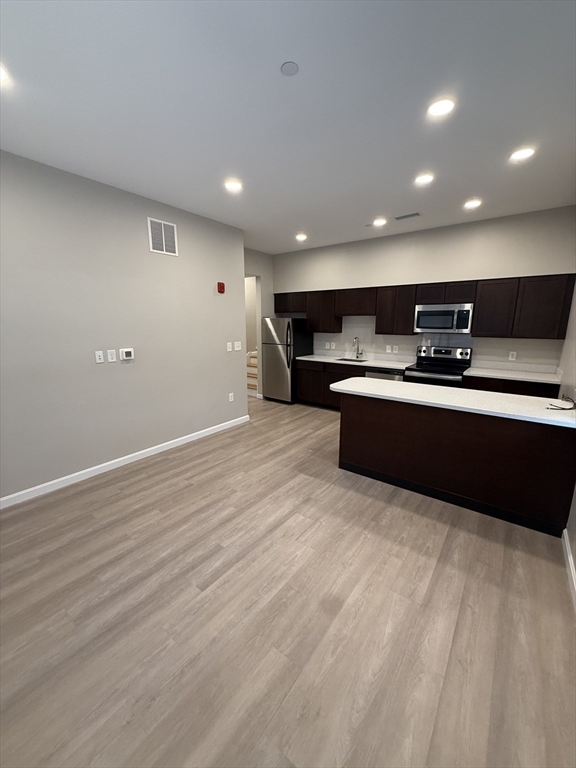 a large kitchen with stainless steel appliances a sink and a stove