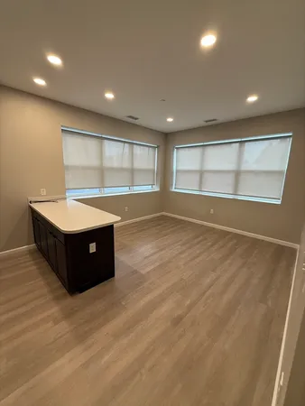 an empty room with a window and ceiling fan
