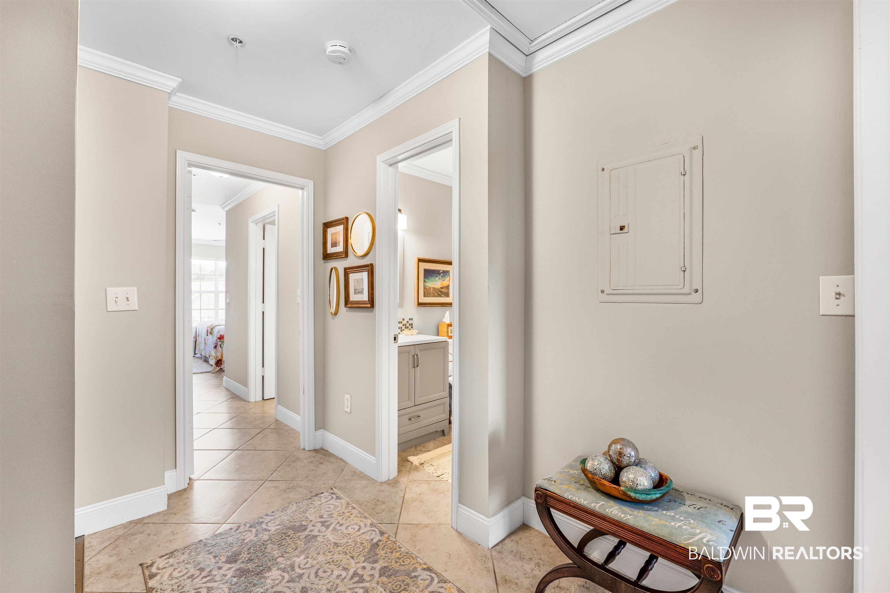 1517 Regency Road, Unit 68 Gulf Shores, AL 36542 - Photo 8 of 43 Corridor with electric panel, ornamental molding, and light tile patterned flooring