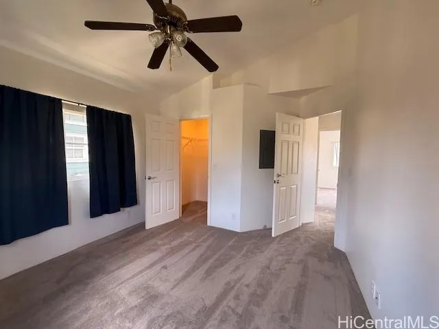 a view of empty room with wooden floor and ceiling fan