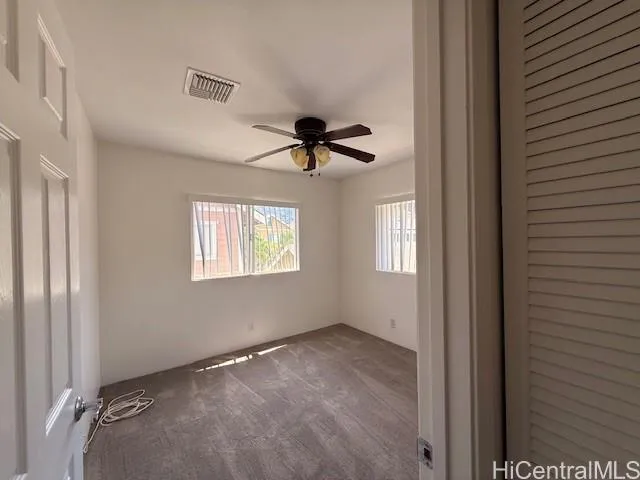 a view of empty room with ceiling fan