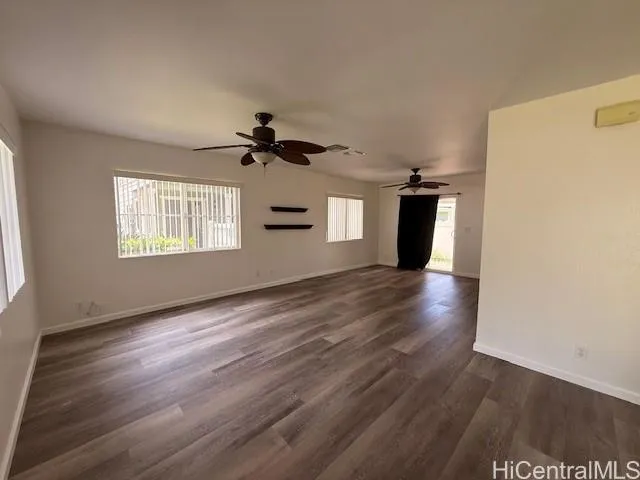 a view of a room with wooden floors and ceiling fan