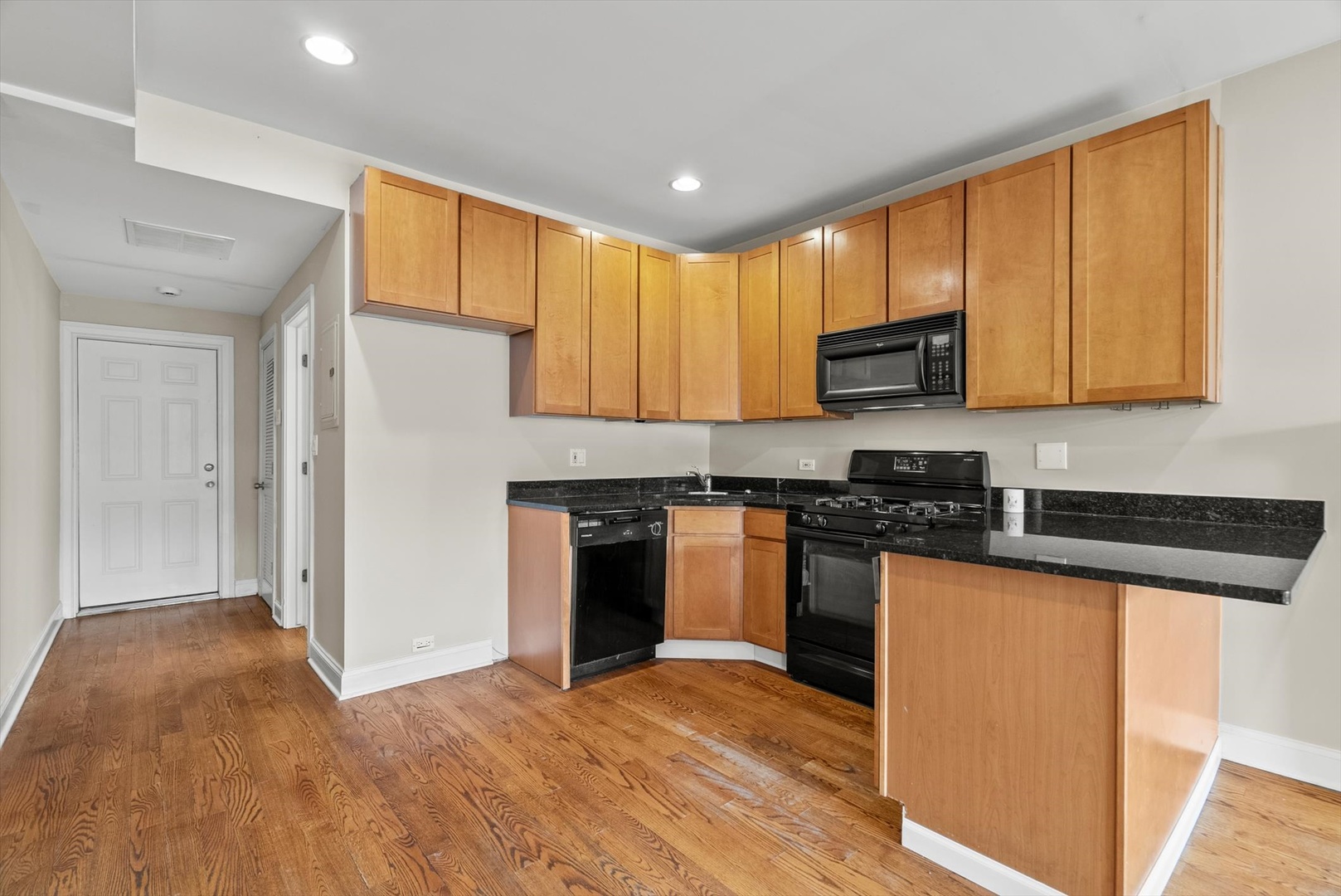 6118 West Addison Street Chicago, IL 60634 - Photo 21 of 35 a kitchen with granite countertop a stove top oven a sink dishwasher and a refrigerator with wooden floor
