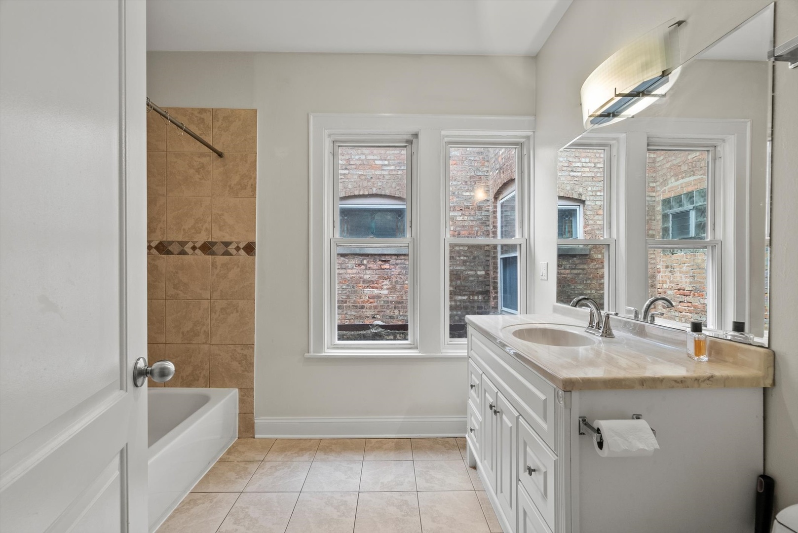 6118 West Addison Street Chicago, IL 60634 - Photo 26 of 35 a bathroom with a granite countertop tub sink and mirror