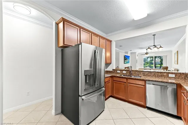a kitchen with granite countertop stainless steel appliances a sink and a refrigerator