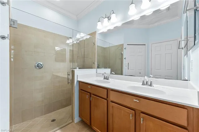 a bathroom with a double vanity sink mirror and shower