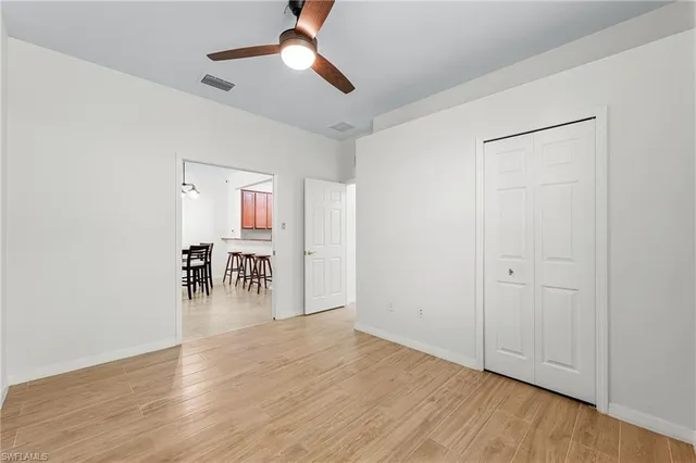 an empty room with wooden floor a ceiling fan and closet