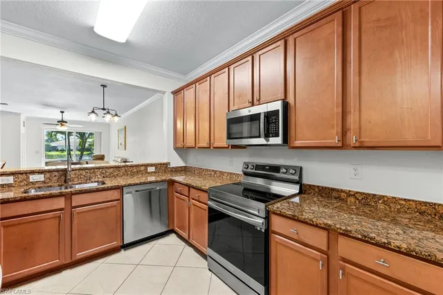 a kitchen with stainless steel appliances granite countertop wooden cabinets and a stove top oven
