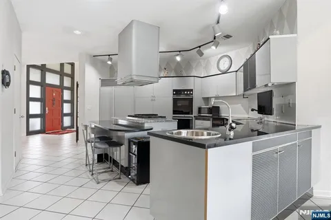 a kitchen with stainless steel appliances granite countertop a sink and a refrigerator