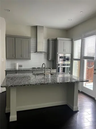 a kitchen with stainless steel appliances granite countertop a sink a stove and cabinets