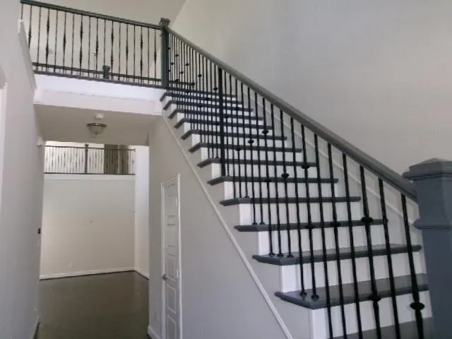 a view of staircase with wooden floor and white walls