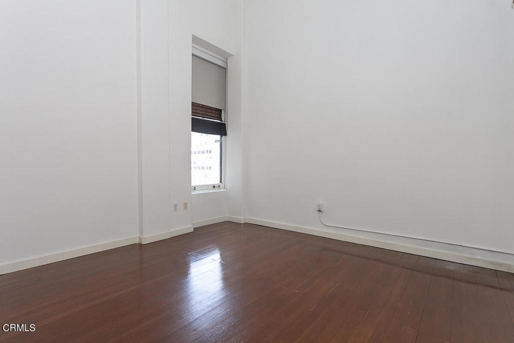 257 South Spring Street, Unit PHE Los Angeles, CA 90012 - Photo 11 of 32 an empty room with wooden floor and windows