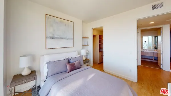 a bedroom with a bed and a painting on the wall