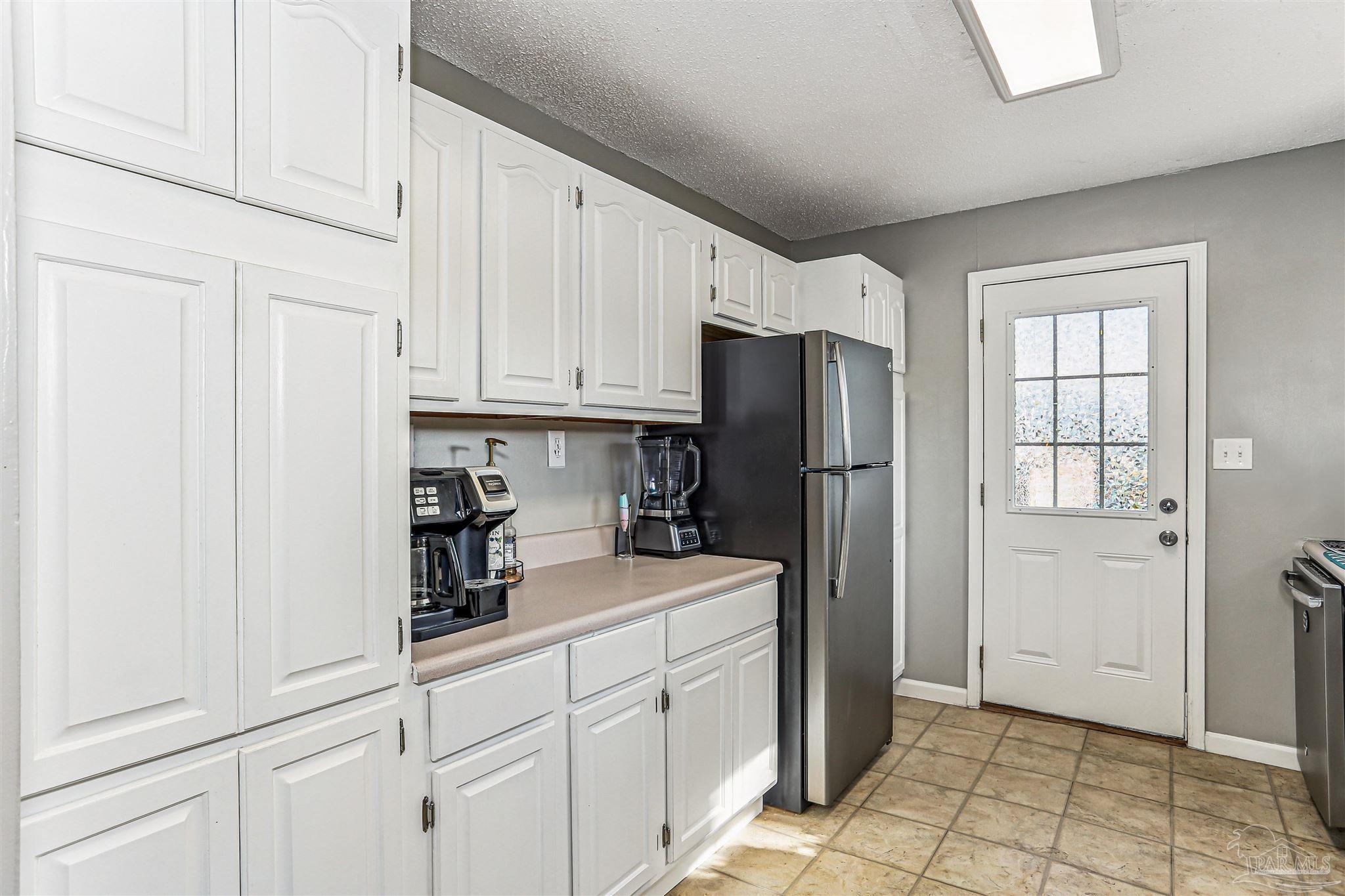 6810 Myra Road Molino, FL 32577 - Photo 12 of 20 a kitchen with a refrigerator and cabinets